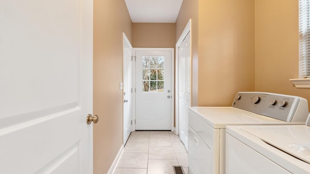 laundry area featuring separate washer and dryer and light tile patterned floors