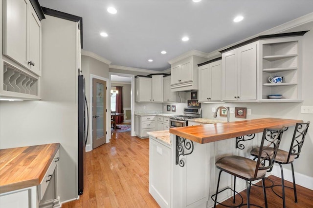 4014 Hawks Way NE, Huntsville, AL 35811 - kitchen with wooden counters, gas range, crown molding, a peninsula, and freestanding refrigerator