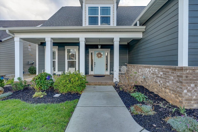 view of exterior entry featuring covered porch