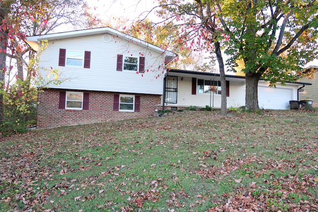 split level home with a garage, covered porch, and a front yard