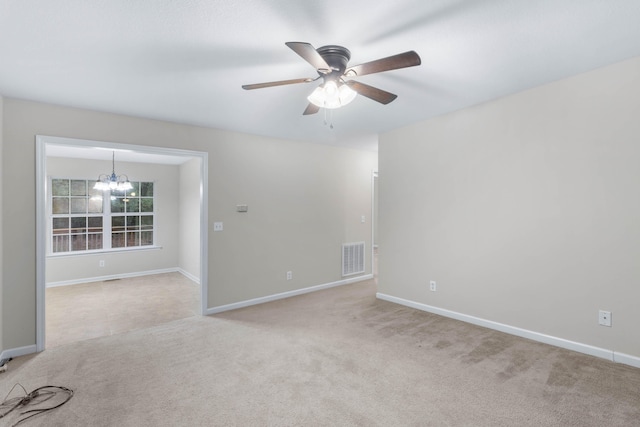 empty room with light carpet and ceiling fan with notable chandelier