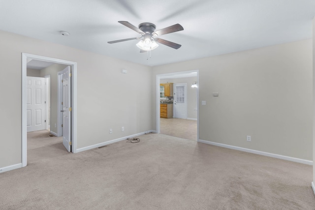 carpeted spare room with ceiling fan