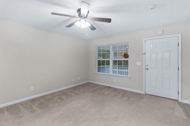 carpeted spare room featuring ceiling fan