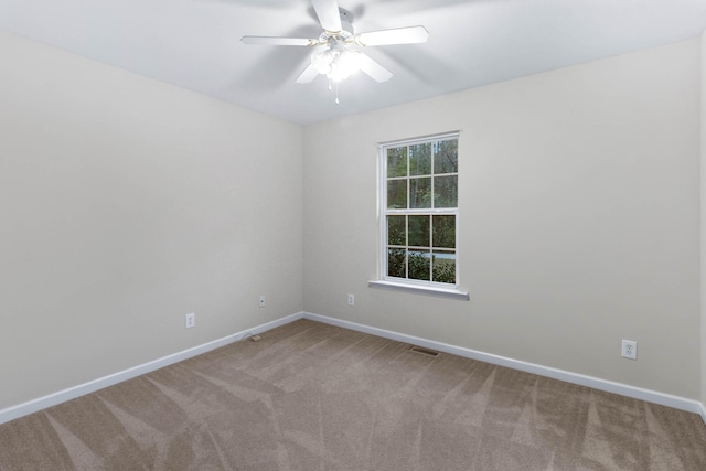 carpeted spare room featuring ceiling fan