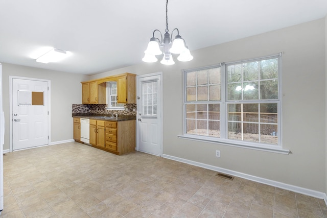 kitchen with pendant lighting, dishwasher, sink, tasteful backsplash, and a chandelier