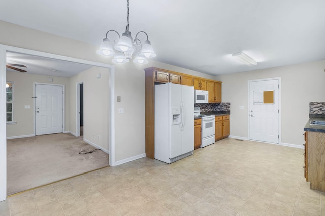 kitchen with white appliances, light carpet, ceiling fan with notable chandelier, hanging light fixtures, and tasteful backsplash