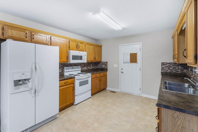 kitchen with decorative backsplash, white appliances, and sink