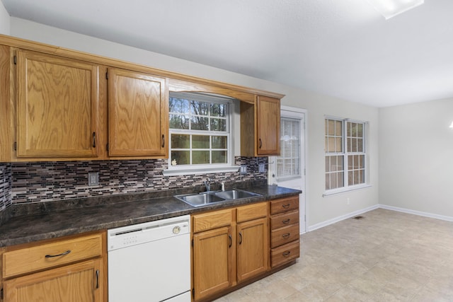 kitchen with dishwasher, decorative backsplash, and sink