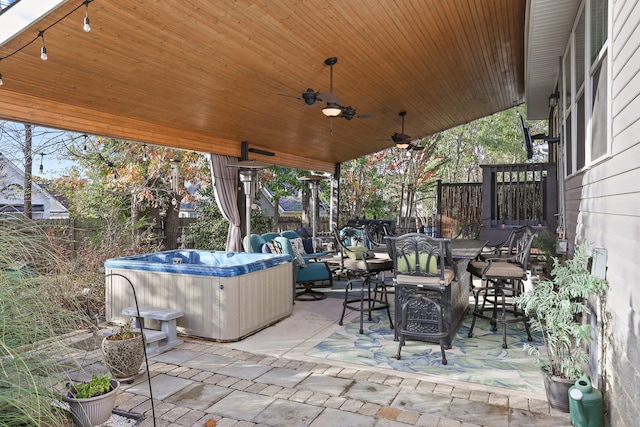 view of patio / terrace with ceiling fan and a hot tub