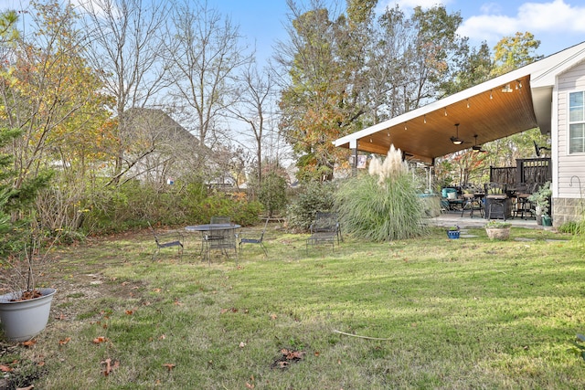 view of yard featuring ceiling fan and a patio