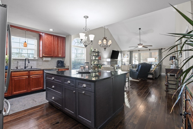 kitchen featuring plenty of natural light, a kitchen island, sink, and dark wood-type flooring