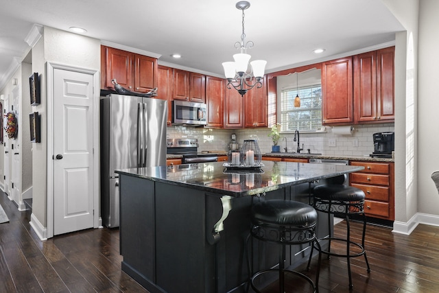 kitchen with stainless steel appliances, dark wood-type flooring, decorative light fixtures, an inviting chandelier, and a kitchen island