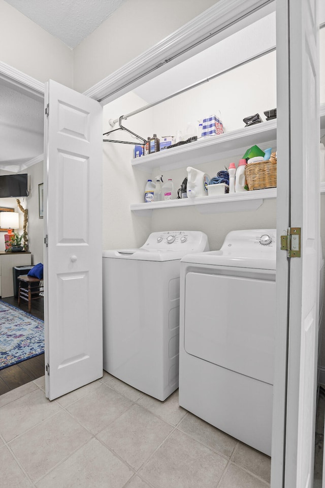 laundry room with light hardwood / wood-style floors, a textured ceiling, and independent washer and dryer