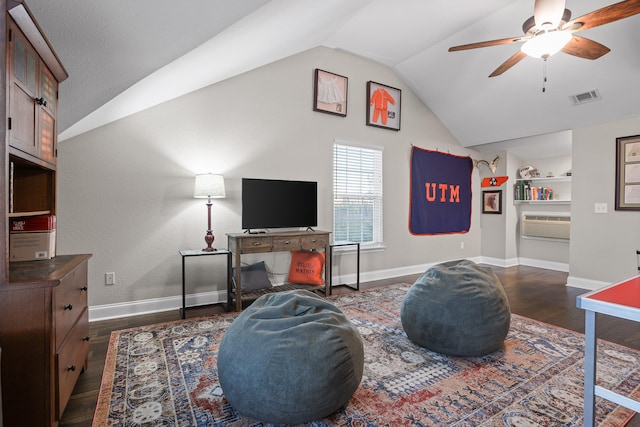 living room with ceiling fan, an AC wall unit, dark wood-type flooring, and vaulted ceiling