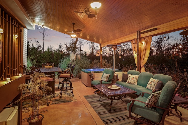 patio terrace at dusk featuring an outdoor hangout area, ceiling fan, and a hot tub