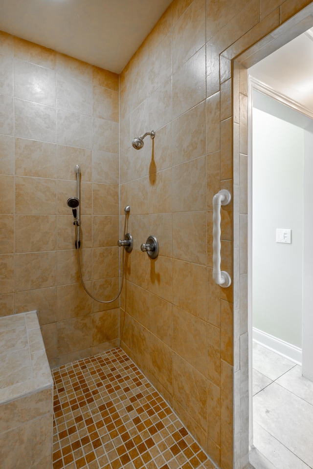 bathroom with a tile shower and tile patterned flooring