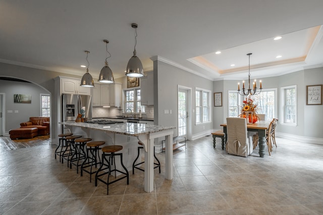 kitchen featuring pendant lighting, light stone counters, plenty of natural light, and appliances with stainless steel finishes