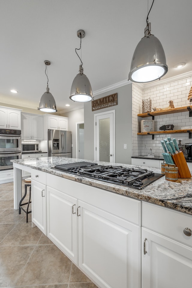 kitchen with decorative light fixtures, white cabinetry, appliances with stainless steel finishes, and tasteful backsplash