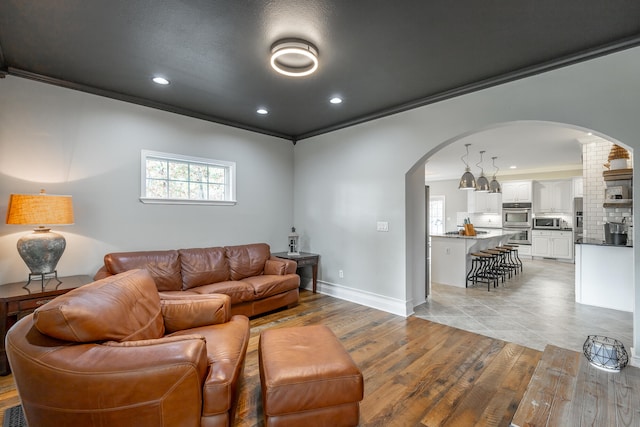 living room with light hardwood / wood-style flooring and crown molding