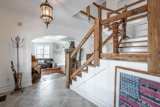 staircase featuring wood-type flooring and crown molding