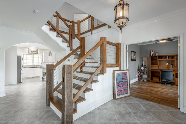 stairway featuring hardwood / wood-style flooring, an inviting chandelier, and crown molding