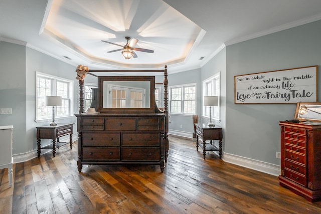 bedroom featuring ornamental molding, a raised ceiling, and dark wood-type flooring