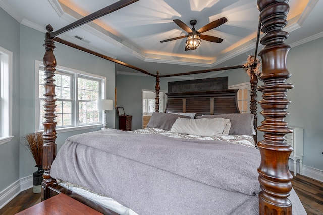 bedroom with a raised ceiling, ceiling fan, crown molding, and dark wood-type flooring