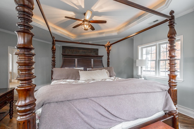 bedroom with a raised ceiling, ceiling fan, dark hardwood / wood-style flooring, and ornamental molding