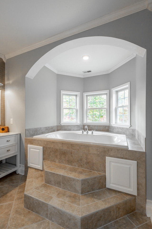 bathroom featuring tile patterned floors, tiled bath, crown molding, and vanity