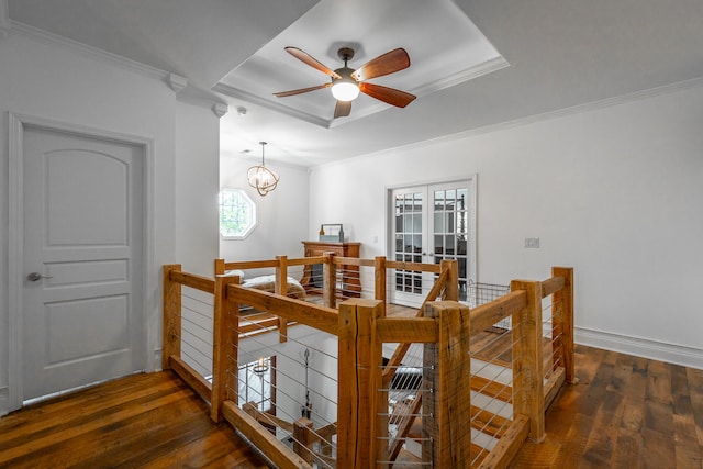 dining space featuring dark hardwood / wood-style floors, a raised ceiling, crown molding, and ceiling fan with notable chandelier