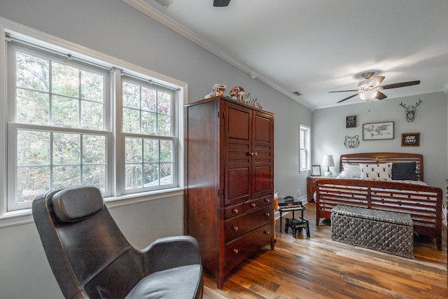 bedroom with ceiling fan, crown molding, and hardwood / wood-style flooring