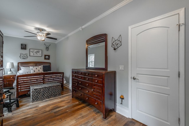 bedroom featuring ceiling fan, dark hardwood / wood-style floors, and ornamental molding