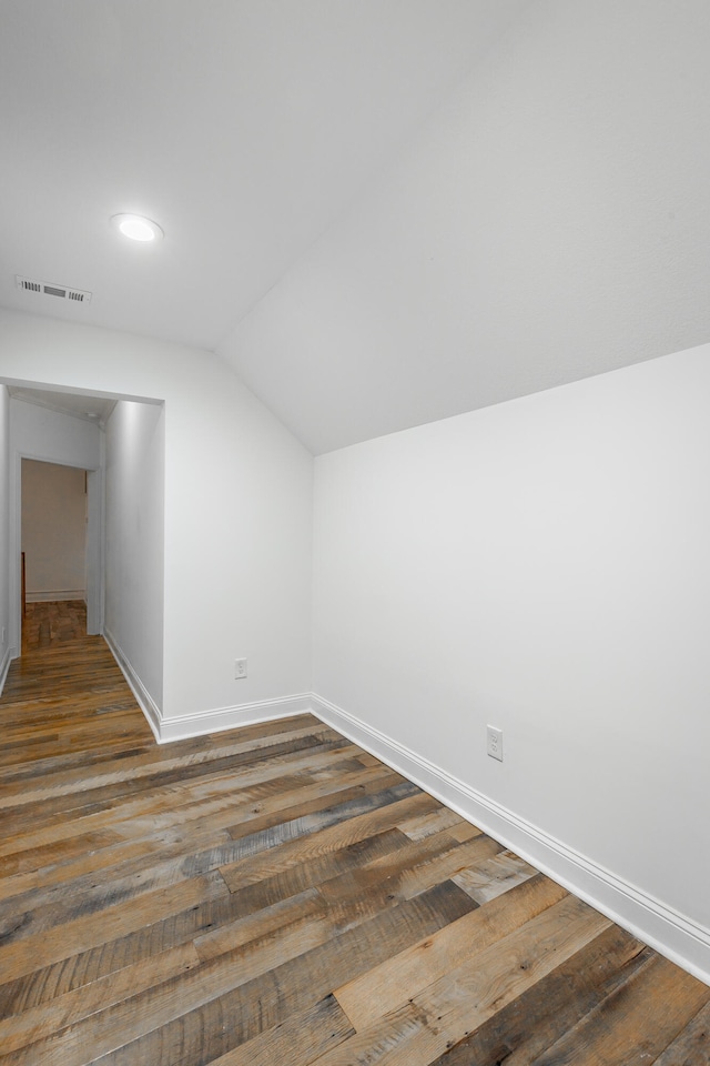 additional living space with dark hardwood / wood-style flooring and vaulted ceiling