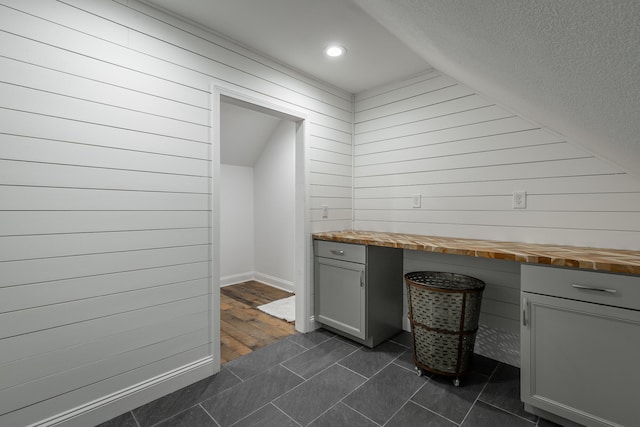 laundry area with wood walls and dark hardwood / wood-style flooring