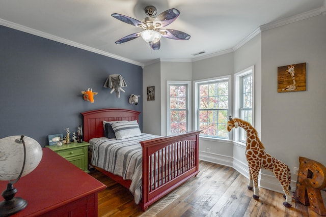 bedroom featuring ceiling fan, hardwood / wood-style floors, and crown molding