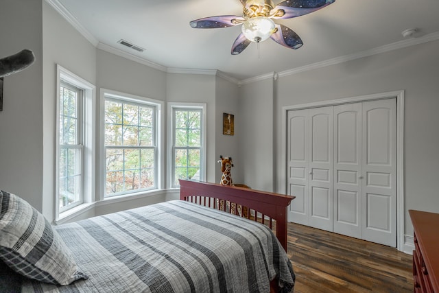 bedroom featuring ceiling fan, ornamental molding, dark wood-type flooring, and a closet