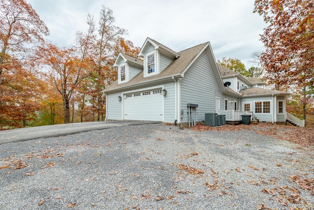 view of side of home featuring cooling unit and a garage