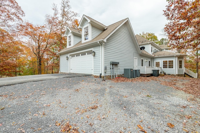 view of side of property featuring cooling unit and a garage