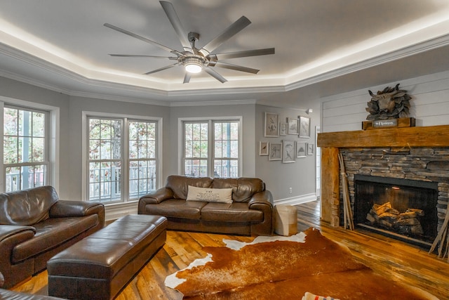 living room featuring ceiling fan, a fireplace, a healthy amount of sunlight, and hardwood / wood-style flooring