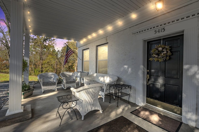 patio terrace at dusk featuring covered porch