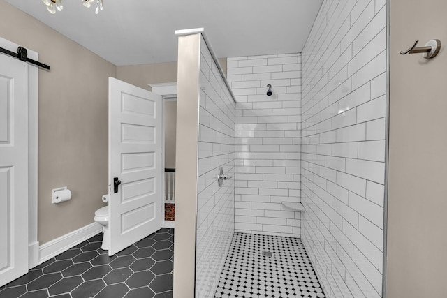 bathroom with tile patterned flooring, tiled shower, and toilet