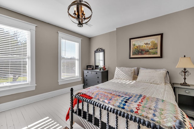 bedroom featuring hardwood / wood-style floors and a chandelier