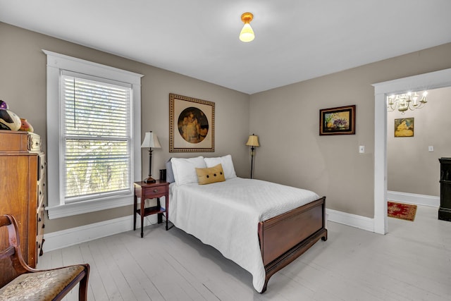 bedroom featuring a chandelier and light wood-type flooring