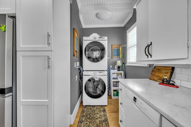 laundry area featuring cabinets, stacked washing maching and dryer, ornamental molding, wooden ceiling, and light hardwood / wood-style floors