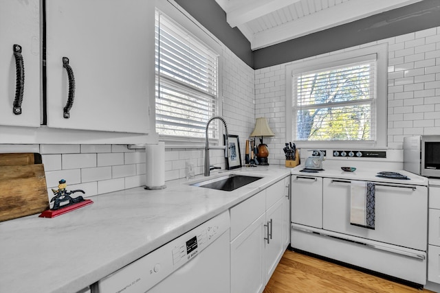 kitchen with white appliances, sink, light hardwood / wood-style flooring, decorative backsplash, and white cabinetry