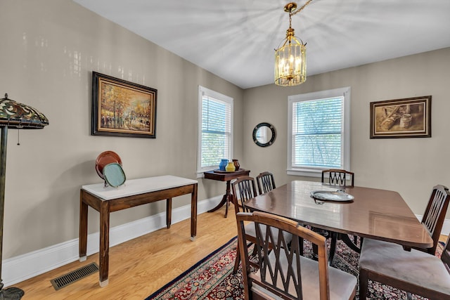 dining space with a notable chandelier and light hardwood / wood-style flooring