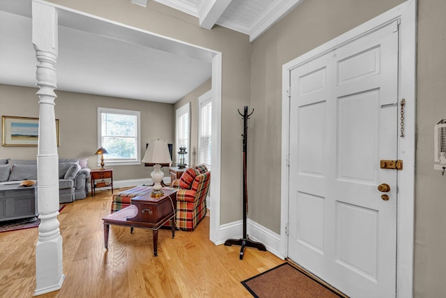 entryway with beam ceiling, light hardwood / wood-style floors, decorative columns, and crown molding