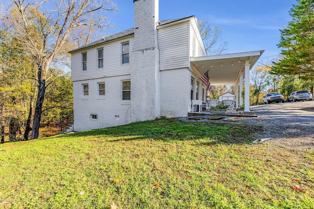 view of home's exterior with covered porch and a yard