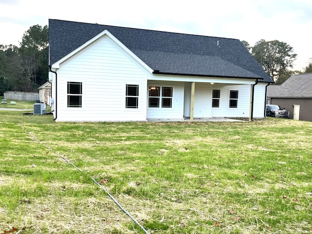 back of property featuring central air condition unit and a lawn