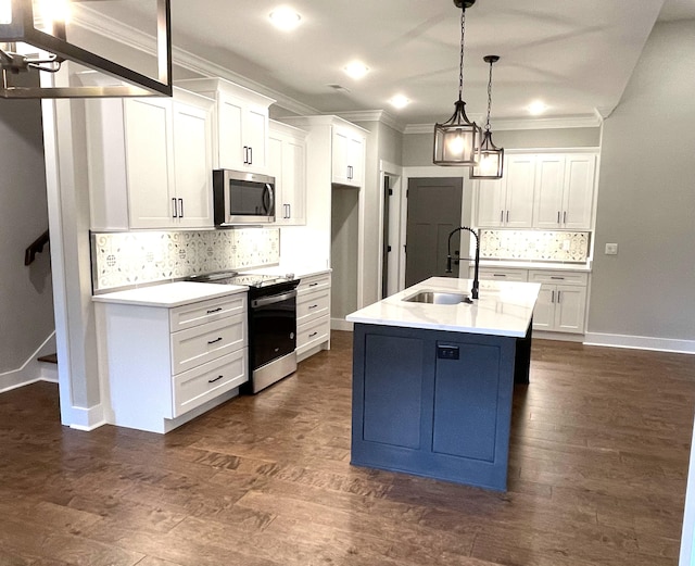 kitchen with a center island with sink, white cabinets, stainless steel appliances, and decorative light fixtures